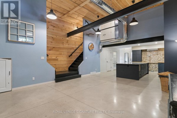 Open concept living area with industrial features, kitchen island, and concrete floors - 24 Davidson Street Cambridge