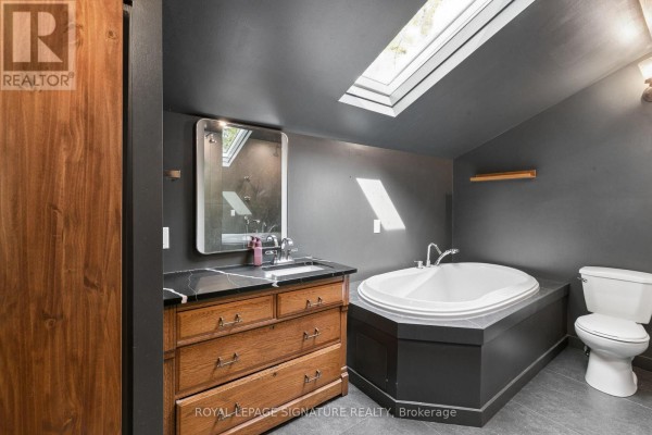 Bathroom with skylight, soaking tub, and wood vanity - 24 Davidson Street Cambridge
