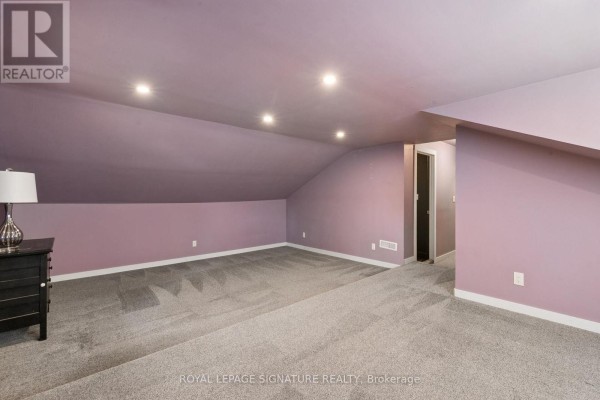 Sloped ceiling room with purple walls and beige carpet - 24 Davidson Street Cambridge