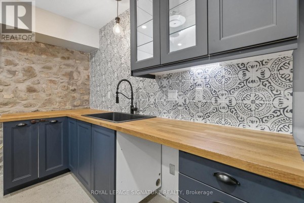 Kitchen with stone wall, blue cabinets, wood counters & patterned tile - 24 Davidson Street Cambridge