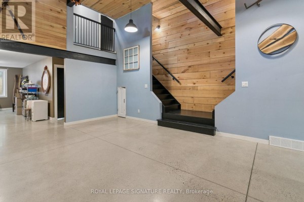 Hallway with wood accent wall, black staircase, and metal beams - 24 Davidson Street Cambridge