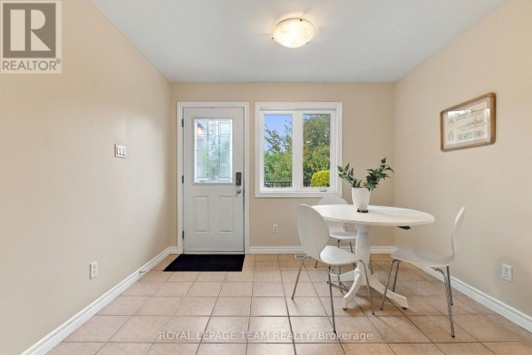 Dining area with beige walls, tiled floor, white table, and four chairs. - 24 Farm Street, Mississippi Mills