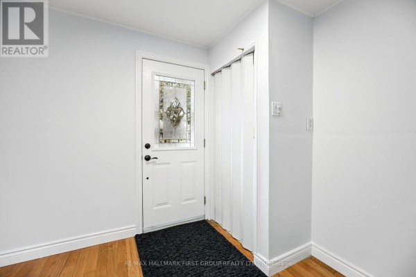 Living room with two grey sofas, a coffee table, a television, and hardwood floors. - 24 George Street, Ajax