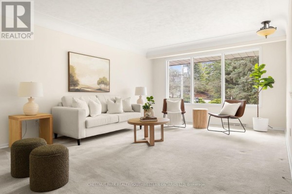 Living room with light carpet, a cream sofa, wooden furniture, and large windows. - 24 Grand Hill Drive, Kitchener