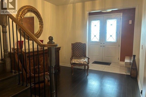 Foyer with double entry doors featuring leaded glass and a mirror above a buffet table. - 24 Heming Trail, Ancaster