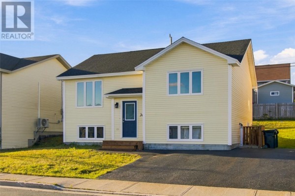 Side view of a yellow house with a blue door, white windows, and green lawn. - 24 Hopedale Crescent, St  John S