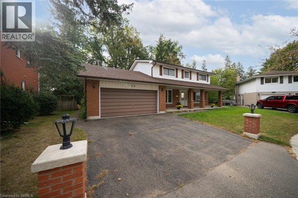 Side exterior view of the house showing the driveway, brick facade, garage, and trees. - 24 Japonica Crescent, Brantford