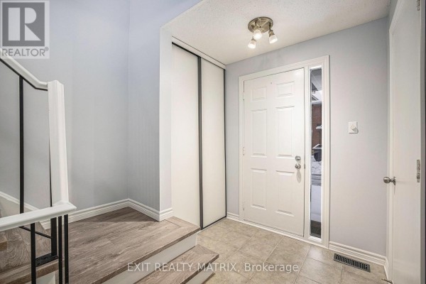 Front entrance of townhouse with landscaped garden and two garages - 24 Oakhaven Private, Ottawa