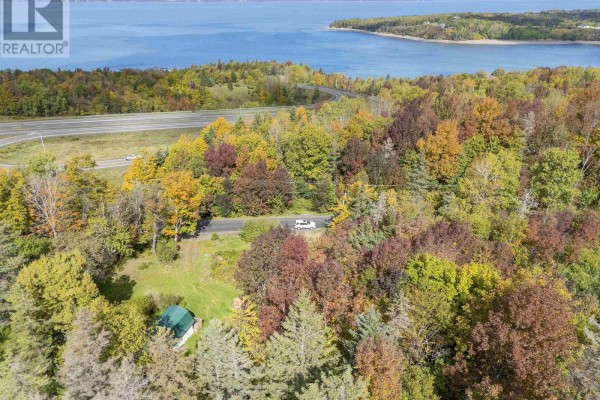 Drone shot of wooded property with autumn foliage, featuring a small building and highway. - 24 Old Post Road, Smiths Cove