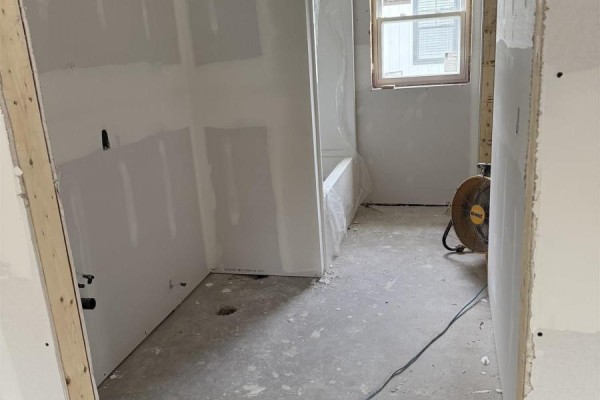 Unfinished bathroom with bathtub, concrete floor, and drywall. - 24 Peterson Street, Cambridge