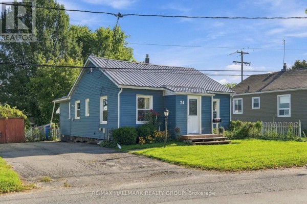 Side view of a blue house with a metal roof and a driveway. - 24 Reuben Cr Crescent, North Grenville