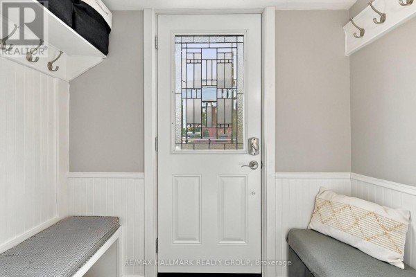 Mudroom entrance with white paneled walls, built-in benches, and hooks. - 24 Reuben Cr Crescent, North Grenville