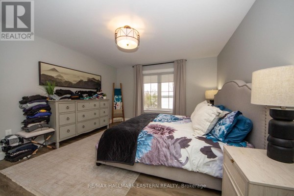 Bedroom with king bed, floral duvet, dresser, and water view window - 24 Rory Drive Selwyn