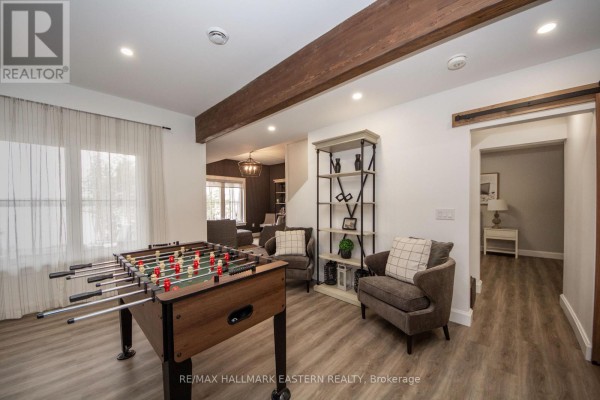 Foosball table and armchairs in living room with wood beam ceiling accent - 24 Rory Drive Selwyn