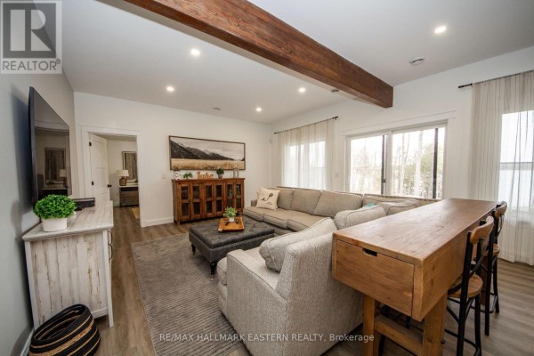Living room with sectional sofa, ottoman, console cabinet, and large windows - 24 Rory Drive Selwyn
