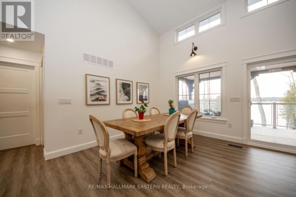 Wooden dining table and chairs with water view through large windows - 24 Rory Drive Selwyn