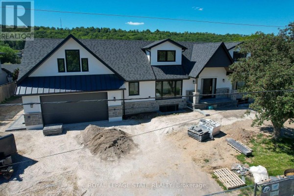 Close-up exterior view of the front of a modern house with a garage and stone detailing. - 24 Royce Avenue, Hamilton