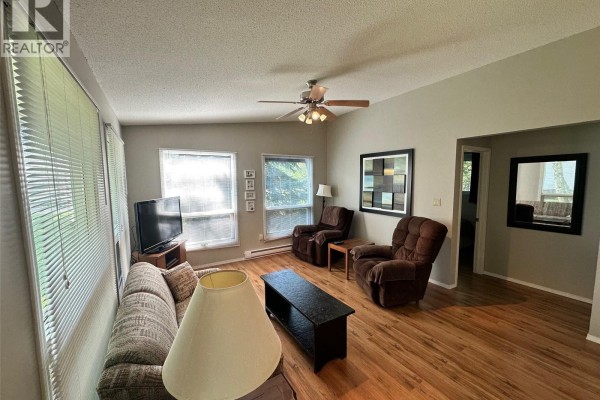 Living room with two chairs, sofa, television, and entrance to another room. - 24 Ruby Crescent, Hudson Bay Rm No  394