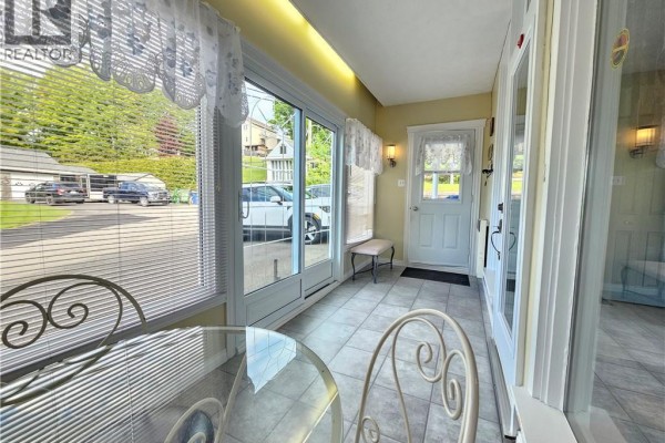 Sunroom with tile floors, large windows, and glass doors. - 24 Rue Veteran Sud, Grand Falls