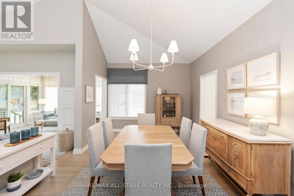 Formal dining room with a wood table, upholstered chairs, textured wallpaper, and a buffet. - 24 Sandpiper Key Way, Markham