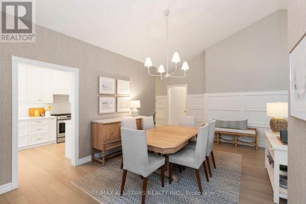 Dining area opening to a kitchen with white cabinets and stainless steel appliances. - 24 Sandpiper Key Way, Markham