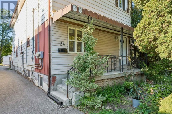 Close-up of the house entrance with a concrete porch, metal railings, and steps. - 24 Victoria Street, Toronto
