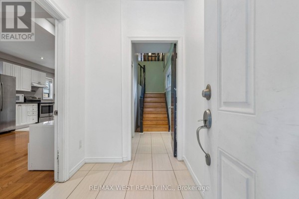 Interior entryway with tile flooring, white walls, and a view of stairs. - 24 Victoria Street, Toronto