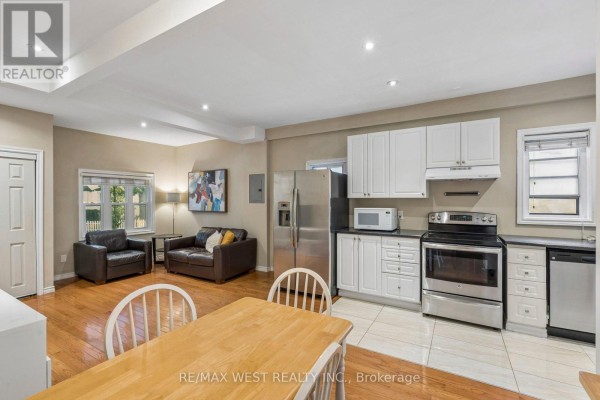 Open concept living space with a kitchen, dining area, and seating area. - 24 Victoria Street, Toronto