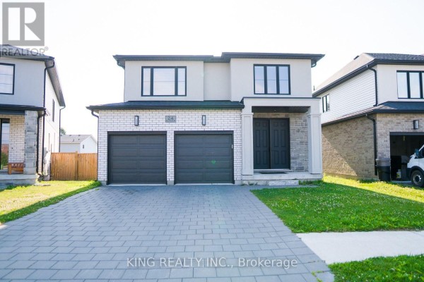 Front exterior of a two-story house with a light beige stucco and white brick facade. - 24 Welch Court, St  Thomas