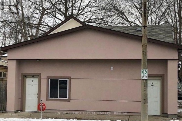 Front exterior of a multi-family building with two entrances labeled '7' and '1 242' on a winter day. - 240-242 East Main Street, Welland