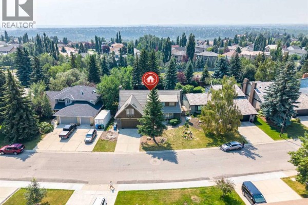 Aerial view showing the house in the context of the surrounding neighborhood and nearby highway. - 240 Canterville Drive Sw, Calgary