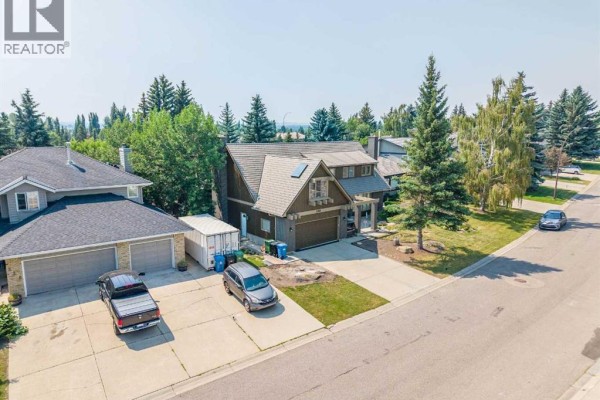 View of the house from the side showing the garage, driveway, and surrounding yards. - 240 Canterville Drive Sw, Calgary