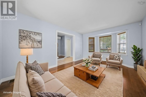 Living room with a couch, chairs, coffee table, and a bay window. - 240 James Street, Timberlea