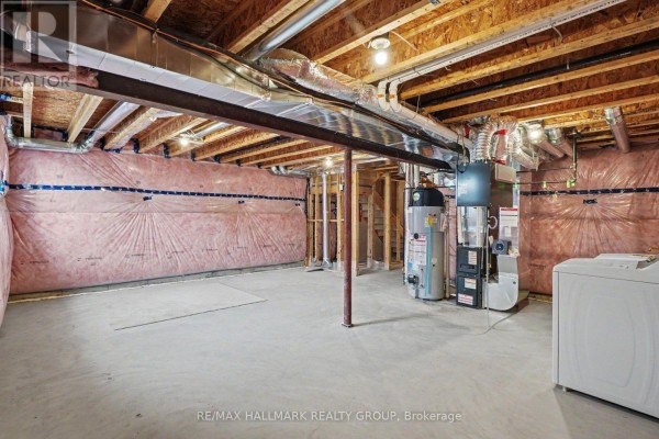 Unfinished basement with water heater, furnace, and washer. - 240 Sweetvalley Drive Ottawa