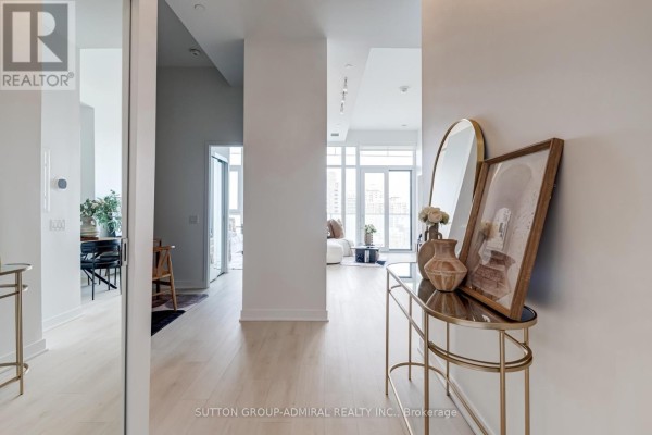Hallway view showing a console table with vases and artwork, leading to living area. - 2401 - 3900 Confederation Parkway, Mississauga