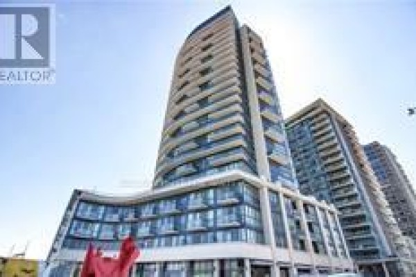 Tall apartment building with glass balconies against a clear blue sky. - 2401 - 51 East Liberty Street, Toronto