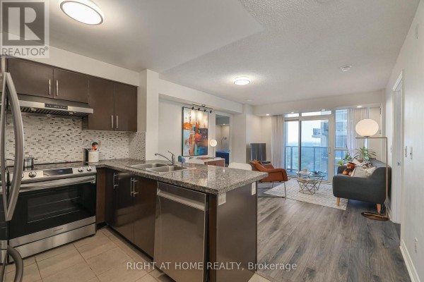 An open-concept living space with a kitchen, dining area, and living room. - 2402 - 3 Michael Power Place, Toronto