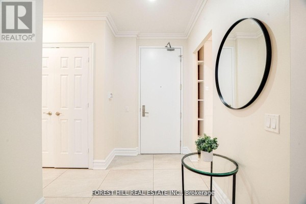 Apartment entrance hallway with tile floor, two doors, and a round mirror. - 2403 - 78 Harrison Garden Boulevard, Toronto