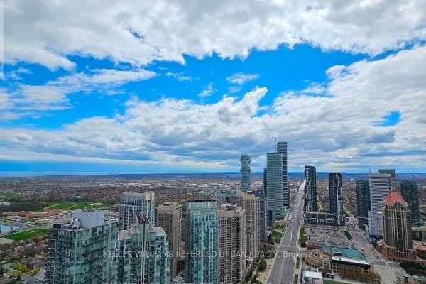 Panoramic view of a dense city skyline with tall buildings under a cloudy blue sky. - 2405 - 4015 The Exchange Drive, Mississauga