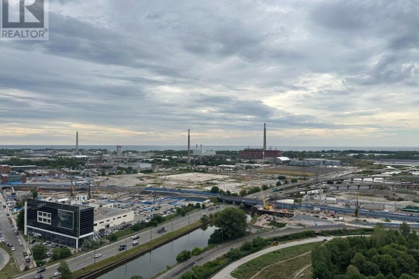 Aerial view of industrial area with canal, highway, and cloudy sky from apartment balcony. - 2407 - 170 Bayview Avenue, Toronto