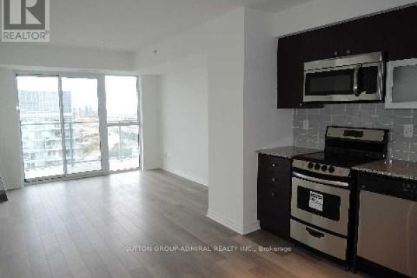 Open concept living area with a kitchen and sliding glass doors to balcony. - 2407 - 275 Yorkland Road, Toronto