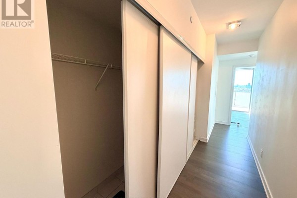 Bedroom with a double bed, floral bedding, dark wood floors, and a balcony door. - 2407 - 57 St Joseph Street, Toronto