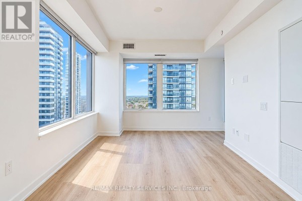 Empty apartment living space with light wood floors and large windows overlooking the city. - 2408 - 395 Square One Drive, Mississauga