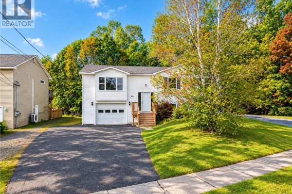 White house with attached garage and driveway on a sunny day. - 241 Claudie Road, Fredericton