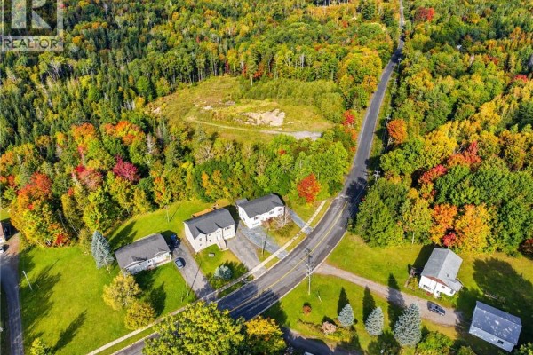 Aerial view of houses on a road surrounded by colourful autumn trees. - 241 Claudie Road, Fredericton