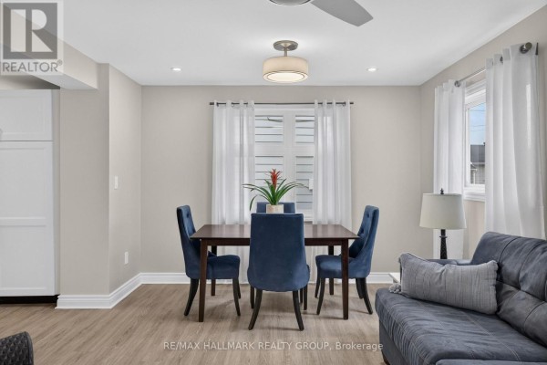 Dining area with dark wood table, blue chairs, and white curtains in a bright room. - 241 Lewis Street E, Edwardsburgh/cardinal