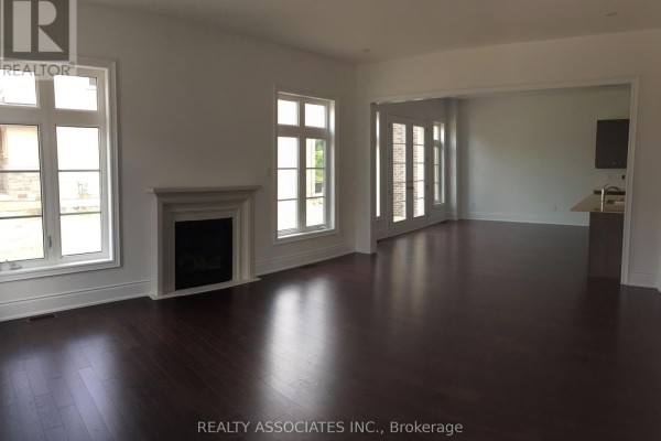 Dining room with dark hardwood floors, a table set for a meal, and a view into a living area. - 241 Stormont Trail, Vaughan