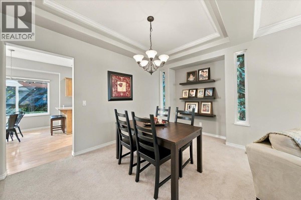 Dining area with a dark wood table, chairs, and a decorative tray on top. - 24100 102 Avenue, Maple Ridge