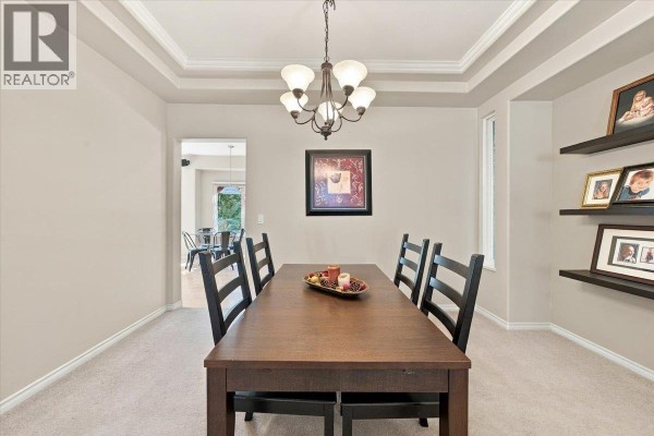 Dining room with a dark wood table, chairs, and three framed photos on floating shelves. - 24100 102 Avenue, Maple Ridge