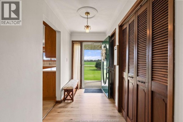 Interior view of the entryway with wood floors, double bi-fold doors, and a view of the backyard. - 24122 Poppe Road, Tilbury